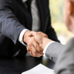 Businessmen shaking hands in office